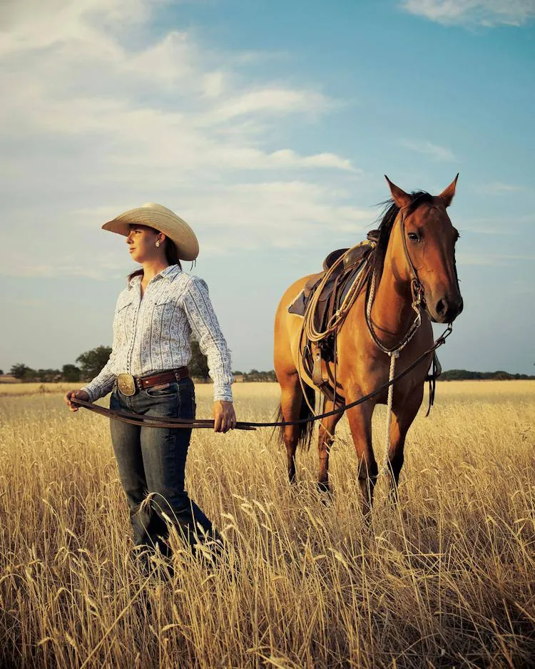Une cavalière et son cheval dans les hautes herbes, au Texas
